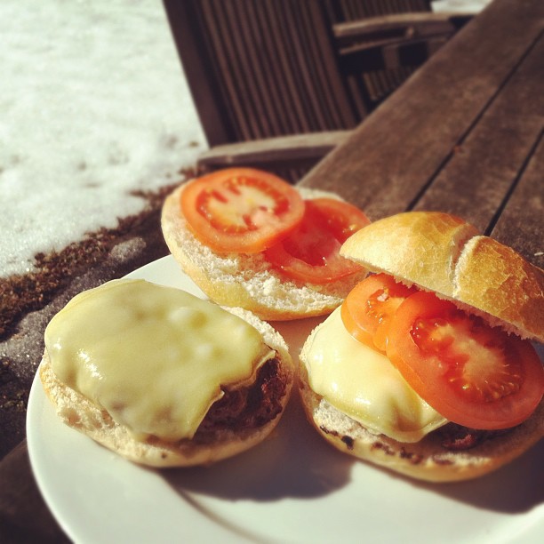Cheeseburgers on the with raclette cheese in the sun and melting snow